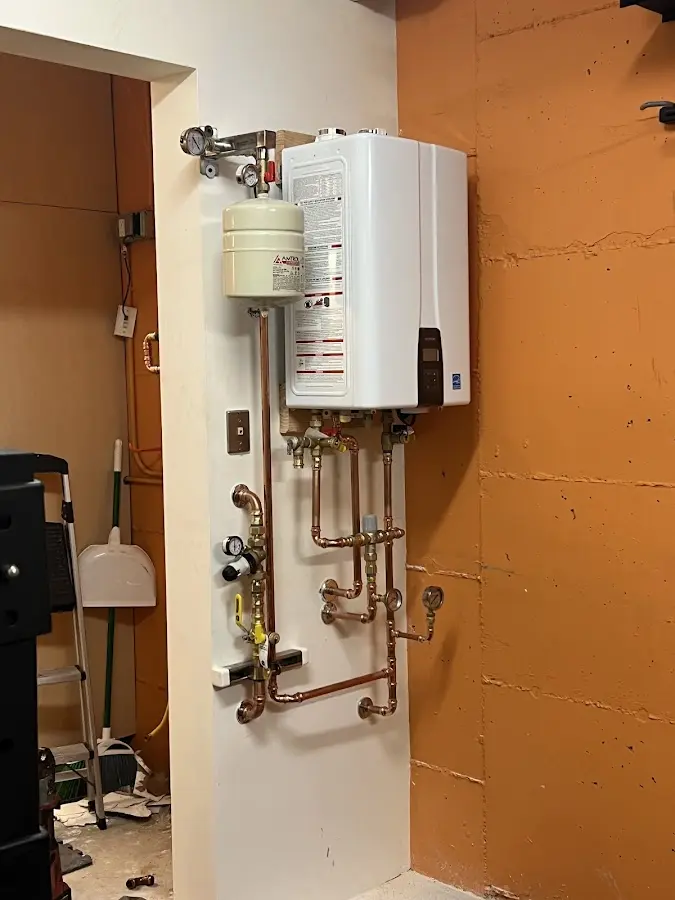 Plumbing technician inspecting water heater connections in Poway